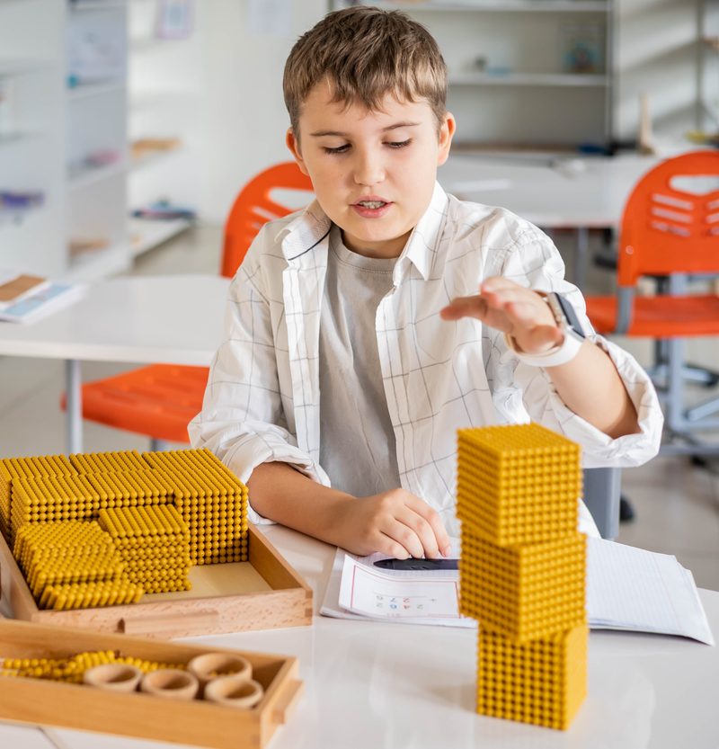Uczeń pracujący ze złotymi perłami Montessori